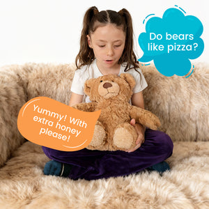 Child holding TalkiPal AI bear toy with text bubbles on a beige couch