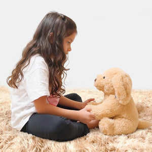 Young girl playing with AI toy Ollie the Pup on a fluffy carpet