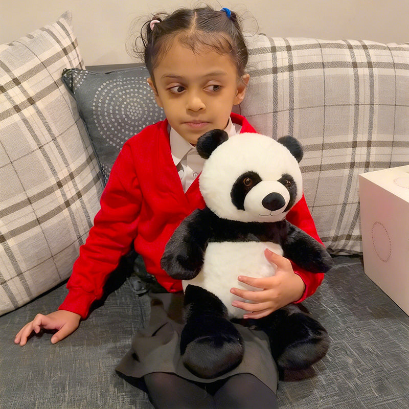 Young girl holding a AI panda plush toy on a couch